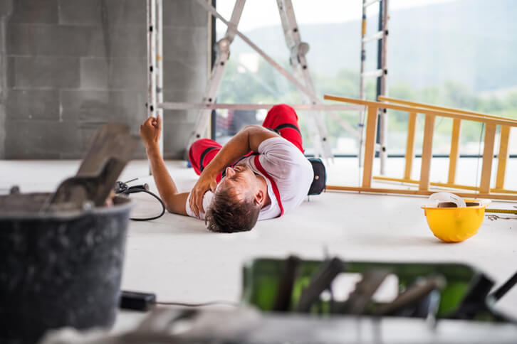 Injured man laying on ground after contruction accident on site