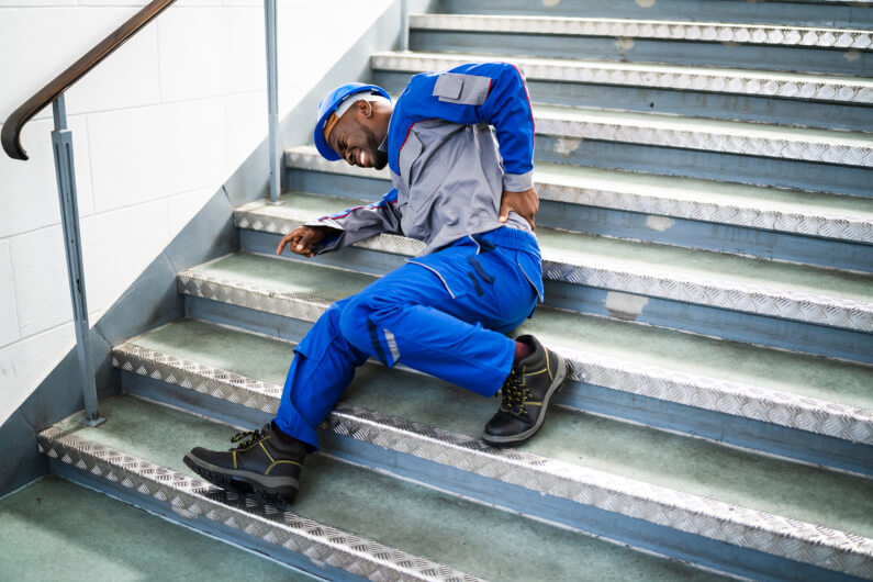 working man laying on staircase after a slip and fall accident