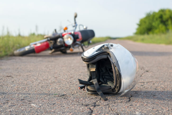 motorcycle and motorcycle helmet laying on ground after motorcycle accident 