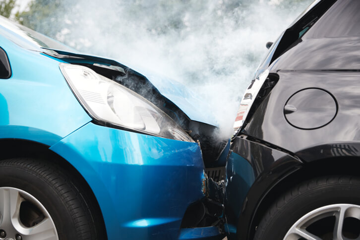 Close up of two damaged cars in head on collision car accident