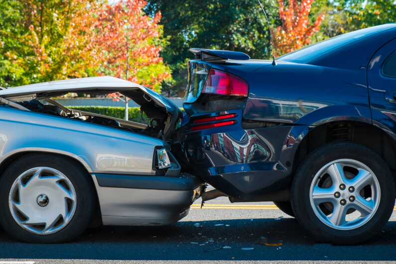  A car with hood bend up after crashing into the back of another car after car accident