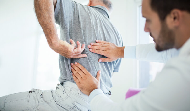 A mans back being examined by a doctor after a back injury