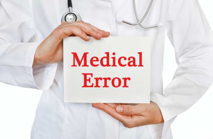 Medical doctor holding card with the words medical error written on card