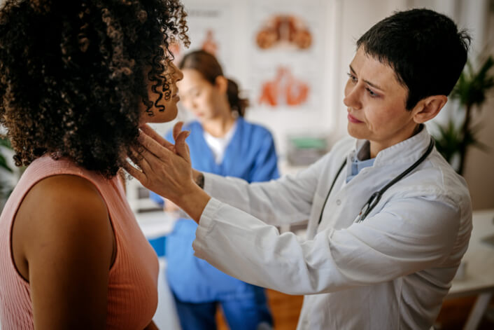Female doctor doing medical examination of a woman's neck to prevent misdiagnosis