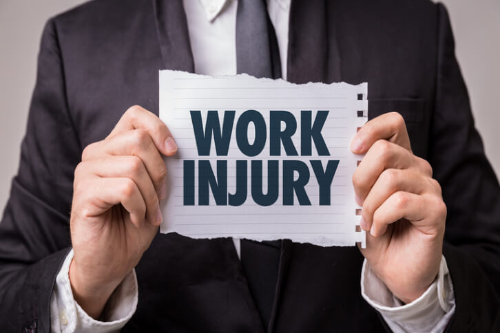man holding up piece of paper saying work injury