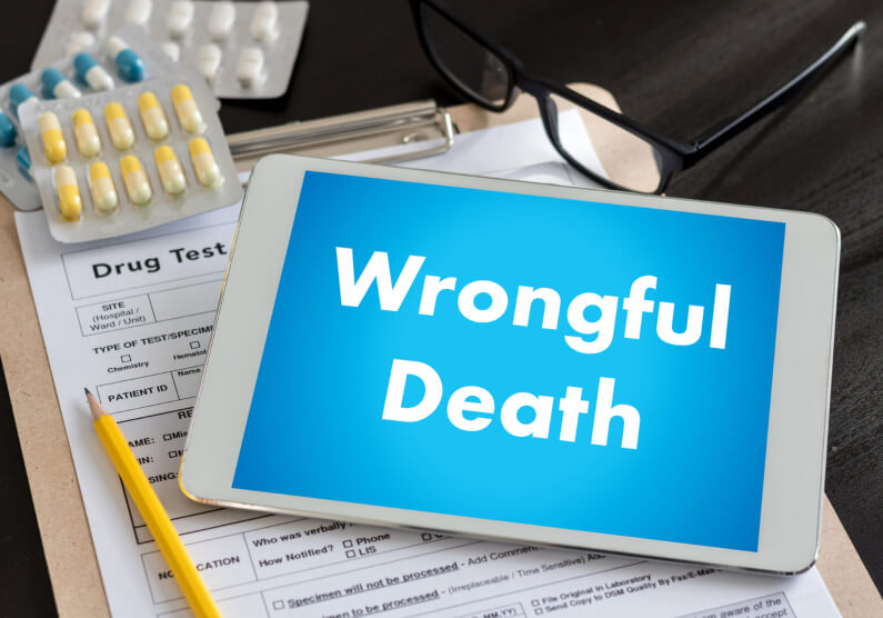 electronic tablet with words wrongful death laying on top of paper next to pills 